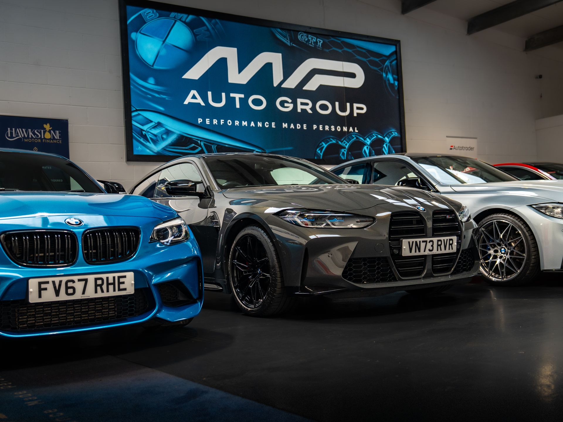 BMW M2, M4 and M3 lined up inside the MP Auto Group showroom