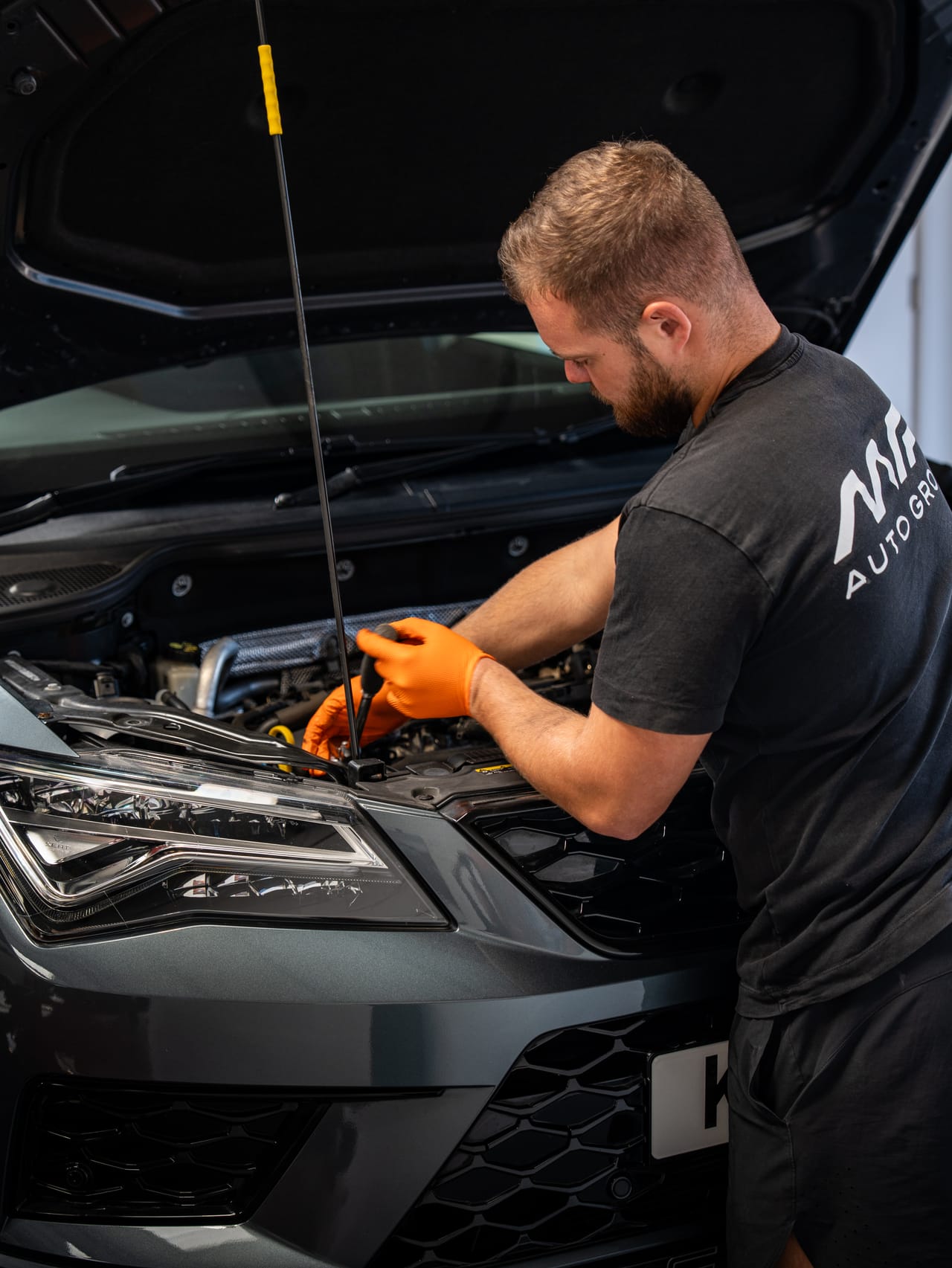 A technician working under the bonnet at MP Auto Group